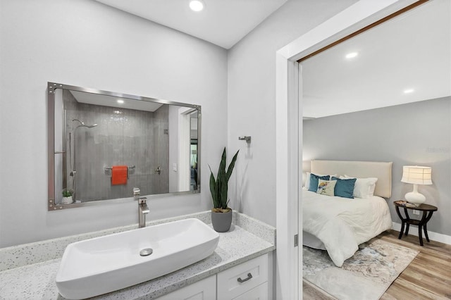 3955 Glen Oaks Manor Dr, Sarasota, FL 34232 - full bathroom with vanity, wood finished floors, tiled shower, and recessed lighting