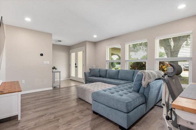 living area with recessed lighting, french doors, and wood finished floors