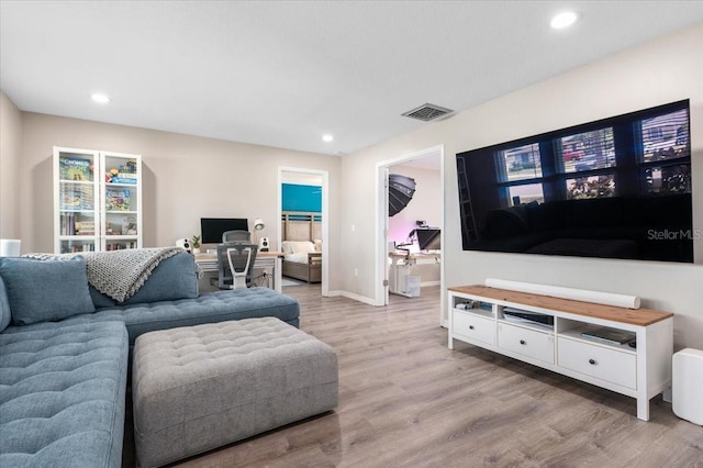 living area with visible vents, light wood-style flooring, baseboards, and recessed lighting