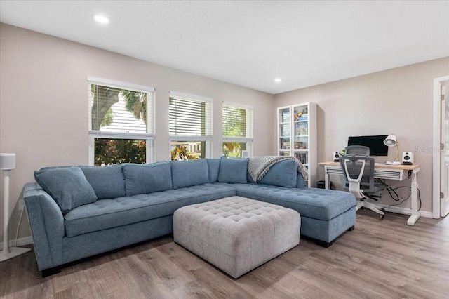 living room with baseboards, light wood-type flooring, and recessed lighting