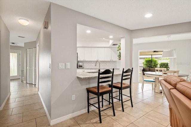 interior space with baseboards, light tile patterned floors, and recessed lighting