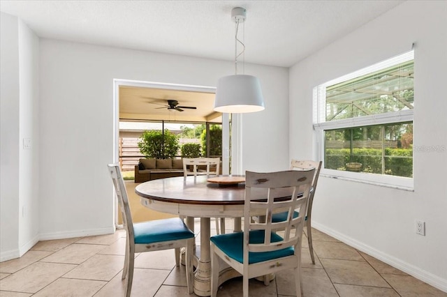 dining room featuring light tile patterned flooring, a wealth of natural light, and baseboards