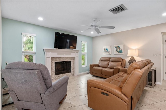 living room with a fireplace, ceiling fan, light tile patterned floors, and visible vents