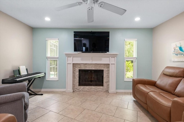 living area featuring baseboards, a fireplace, a ceiling fan, and recessed lighting