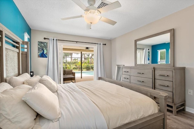 bedroom with a textured ceiling, baseboards, ceiling fan, wood finished floors, and access to exterior