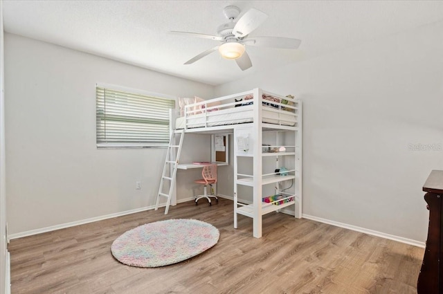 bedroom featuring wood finished floors, baseboards, and ceiling fan