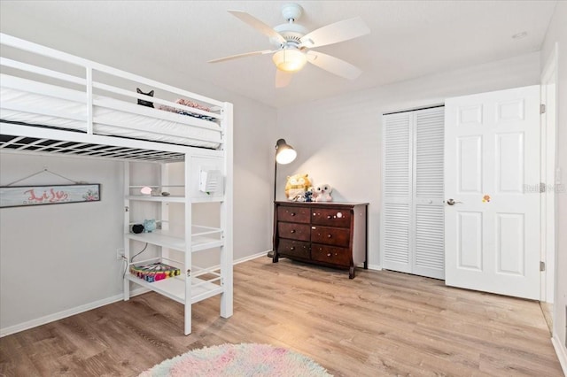 bedroom featuring baseboards, a closet, light wood-type flooring, and a ceiling fan