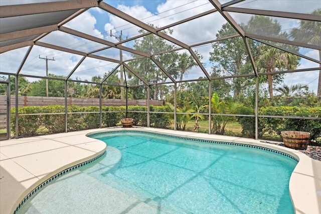 pool featuring fence, a patio, and glass enclosure