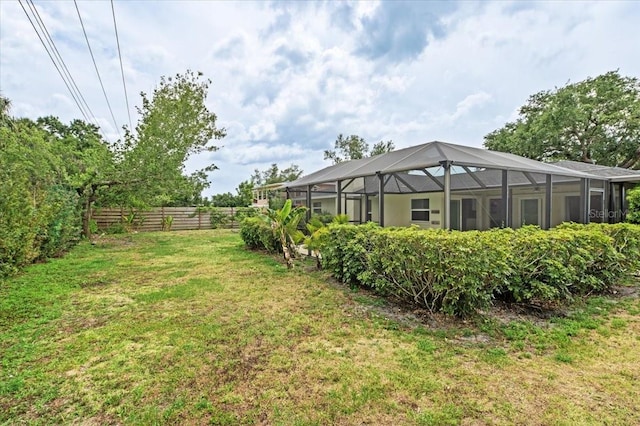 view of yard featuring a lanai and fence