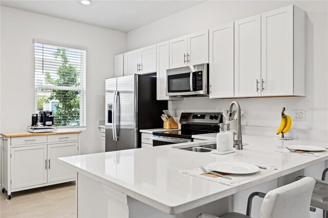 8545 Daybreak St, Sarasota, FL 34241 - kitchen with white cabinets, appliances with stainless steel finishes, a sink, light countertops, and a peninsula