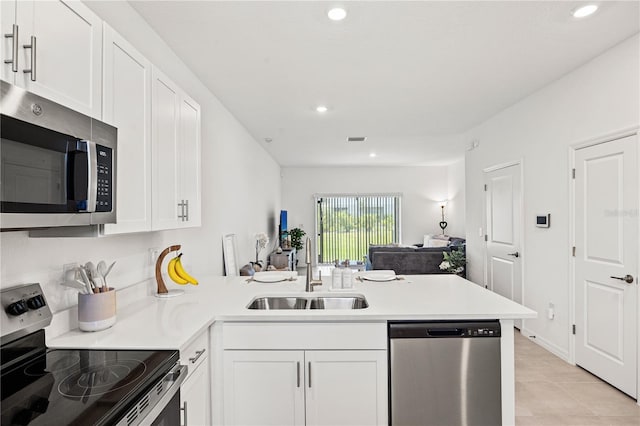 8545 Daybreak St, Sarasota, FL 34241 - kitchen featuring a peninsula, recessed lighting, white cabinets, a sink, and appliances with stainless steel finishes