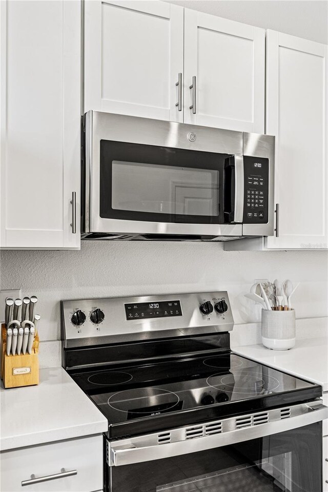 8545 Daybreak St, Sarasota, FL 34241 - kitchen featuring light countertops, white cabinets, and stainless steel appliances