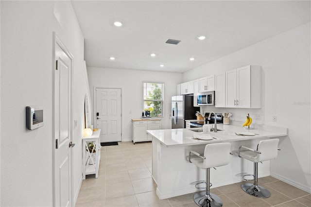 8545 Daybreak St, Sarasota, FL 34241 - kitchen featuring a sink, stainless steel appliances, white cabinetry, a peninsula, and visible vents