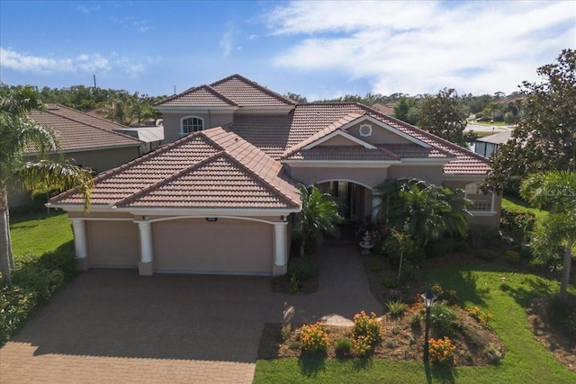 6951 Scrub Jay Dr, Sarasota, FL 34241 - mediterranean / spanish-style home featuring decorative driveway, an attached garage, a tile roof, and stucco siding
