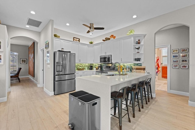9012 Province St, Sarasota, FL 34240 - kitchen featuring appliances with stainless steel finishes, arched walkways, a peninsula, a sink, and a breakfast bar