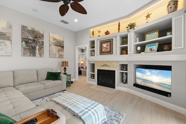 9012 Province St, Sarasota, FL 34240 - living room with baseboards, a ceiling fan, wood finished floors, built in shelves, and a fireplace