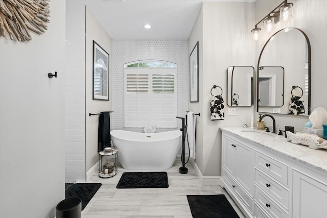 9012 Province St, Sarasota, FL 34240 - bathroom with baseboards, vanity, a freestanding tub, a tile shower, and recessed lighting