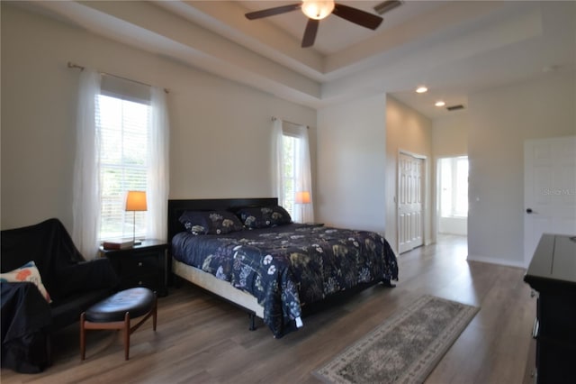 bedroom with wood finished floors and multiple windows