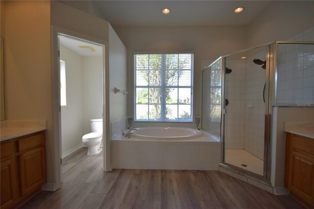 full bath with a shower stall, wood finished floors, a garden tub, and vanity