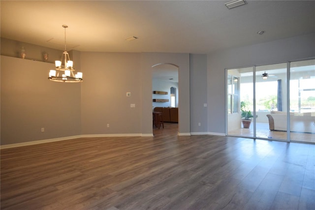 empty room with visible vents, dark wood-style flooring, baseboards, arched walkways, and ceiling fan with notable chandelier