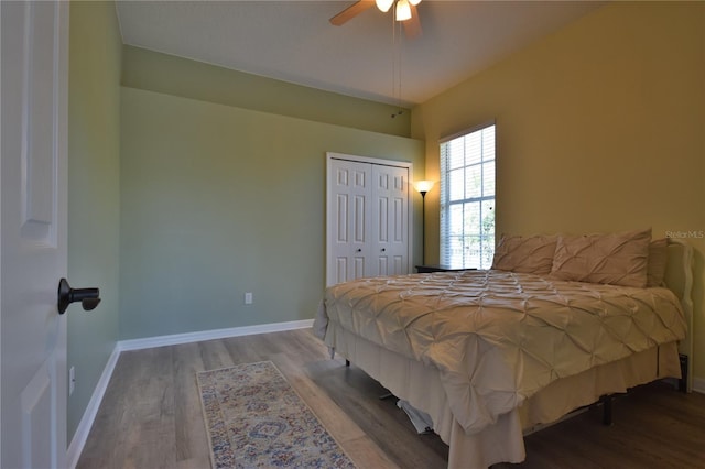 bedroom featuring baseboards, wood finished floors, and a closet
