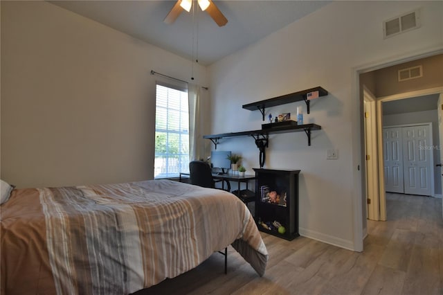 bedroom featuring a ceiling fan, baseboards, visible vents, and light wood-type flooring
