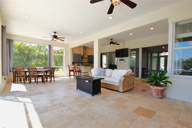 living area featuring ceiling fan, recessed lighting, and stone tile floors