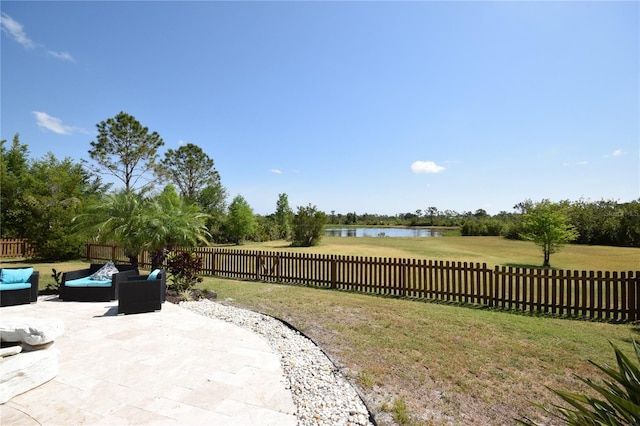 view of yard featuring an outdoor living space, a water view, a patio area, and a fenced backyard