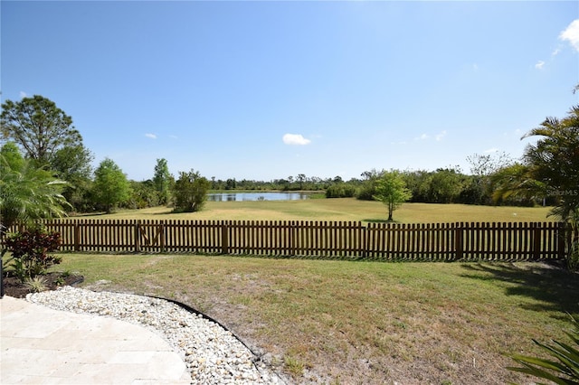 view of yard with a water view and fence