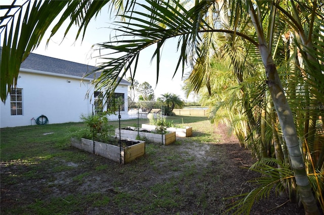 view of yard featuring fence and a garden