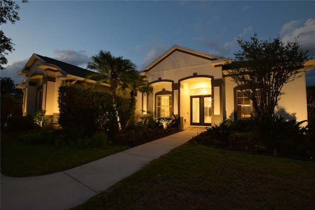 mediterranean / spanish house with a front lawn and stucco siding