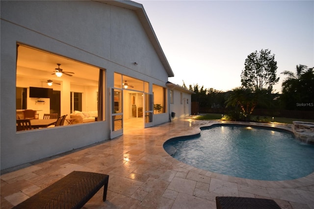 pool at dusk with a patio and an outdoor pool