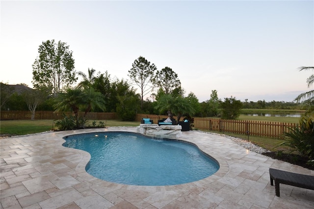 pool at dusk with a water view, a fenced in pool, a fenced backyard, and a patio area