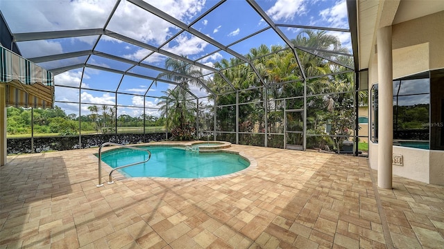 view of swimming pool with a lanai, a pool with connected hot tub, and a patio area