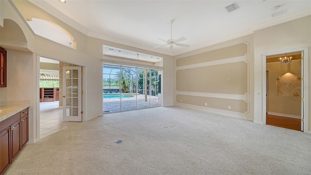 unfurnished dining area featuring visible vents, plenty of natural light, ceiling fan with notable chandelier, and light carpet