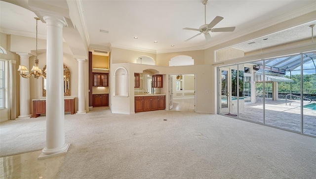 unfurnished living room with ornamental molding, a towering ceiling, ceiling fan, light colored carpet, and a sink