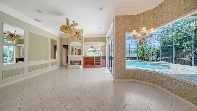 view of swimming pool with a glass covered fireplace, a pool with connected hot tub, and ceiling fan with notable chandelier