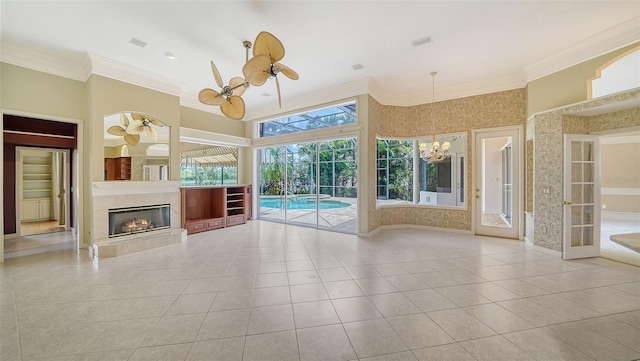 unfurnished living room with visible vents, ornamental molding, tile patterned flooring, and ceiling fan with notable chandelier
