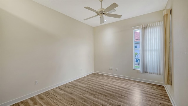 spare room with baseboards, a ceiling fan, and wood finished floors