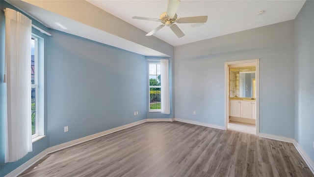 empty room with baseboards, a ceiling fan, and wood finished floors