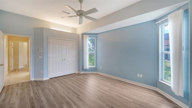 unfurnished bedroom with ceiling fan, light wood-style flooring, baseboards, visible vents, and a closet