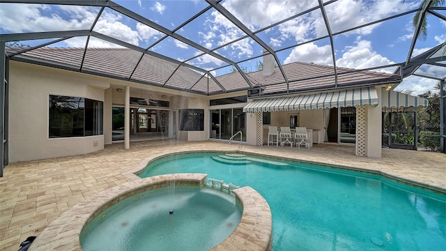 view of swimming pool with a lanai, a pool with connected hot tub, and a patio area