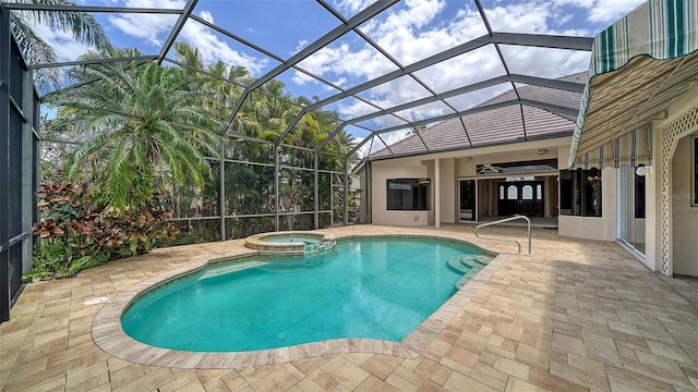 view of pool with a patio, ceiling fan, a pool with connected hot tub, and glass enclosure