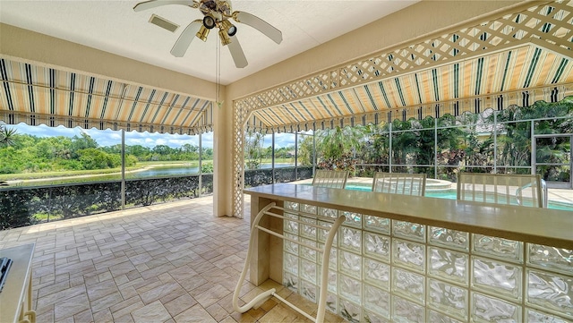 exterior space featuring a ceiling fan, visible vents, a pool with connected hot tub, and a water view
