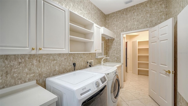 washroom with independent washer and dryer, visible vents, cabinet space, a sink, and light tile patterned floors
