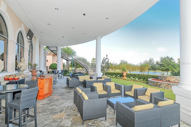 view of patio / terrace featuring stairway, a water view, outdoor lounge area, and outdoor dining space