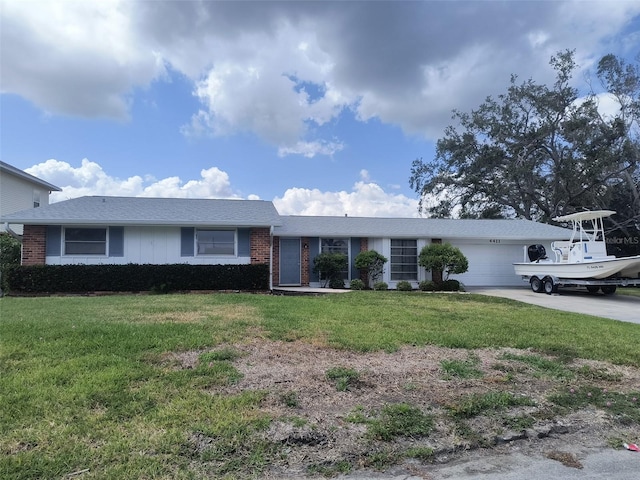 4411 Dolphin Ln, Palmetto, FL 34221 - ranch-style house with an attached garage, concrete driveway, a front lawn, and brick siding