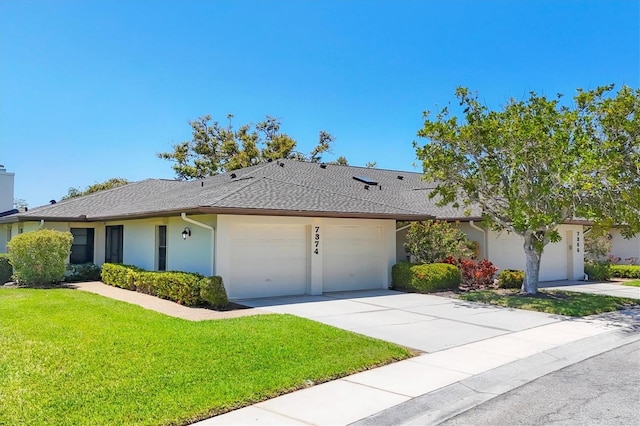 7374 Royal Birkdale Dr Unit 15D, Sarasota, FL 34238 - single story home with a shingled roof, a front lawn, a garage, stucco siding, and concrete driveway