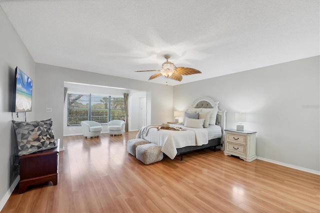 7374 Royal Birkdale Dr Unit 15D, Sarasota, FL 34238 - bedroom with baseboards, a ceiling fan, light wood finished floors, and a textured ceiling
