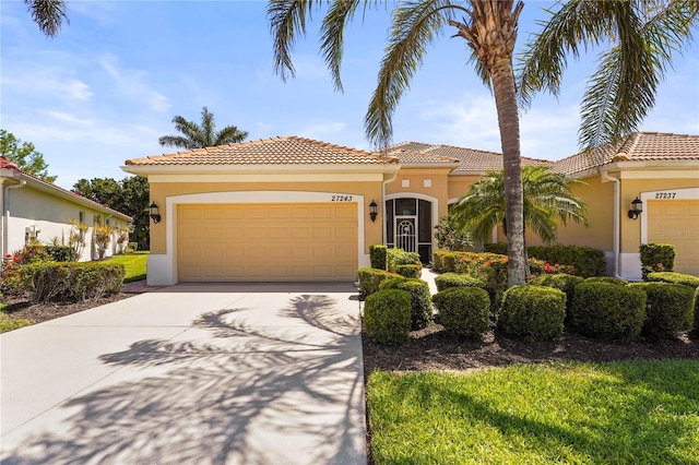 27243 Ipswich Dr, Englewood, FL 34223 - mediterranean / spanish house featuring a garage, stucco siding, concrete driveway, and a tiled roof